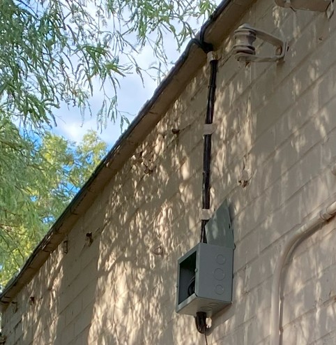 Professional cable installation along rear exterior of building